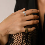 Model wearing the Triangle Ring, a silver ring featuring a row of triangle-shaped cubic zirconia stones and the Y Punto Pinky ring.
