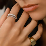 Model wearing the Triangle Ring, a silver ring featuring a row of triangle-shaped cubic zirconia stones and the Y Punto Pinky ring.
