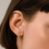 The Prong Hoops, which are a pair of dainty gold hoop earrings, feature sparkling prong-set crystals that add a touch of elegance and subtle shine. These versatile earrings are perfect for everyday wear or layering with other pieces to create a sophisticated, modern look. ||| GOLD