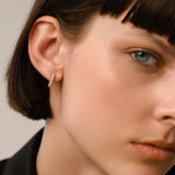 The Prong Hoops, which are a pair of dainty gold hoop earrings, feature sparkling prong-set crystals that add a touch of elegance and subtle shine. These versatile earrings are perfect for everyday wear or layering with other pieces to create a sophisticated, modern look. ||| SILVER