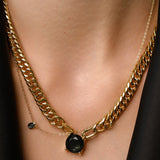Model wearing The Emerald Dot Necklace Set, a two-piece gold necklace featuring a delicate chain with a single emerald pendant and a matching choker chain.