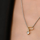 Model wearing the SOLITAIRE LILY NECKLACE which is a thin mini can opener necklace with a mini diamond flower pendant.