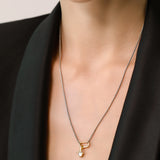 Model wearing the SOLITAIRE LILY NECKLACE which is a thin mini can opener necklace with a mini diamond flower pendant.