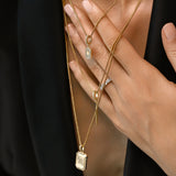 Model wearing the You and the Needle Necklace Set, a three-piece gold necklace set with a needle pendant and initial charm.