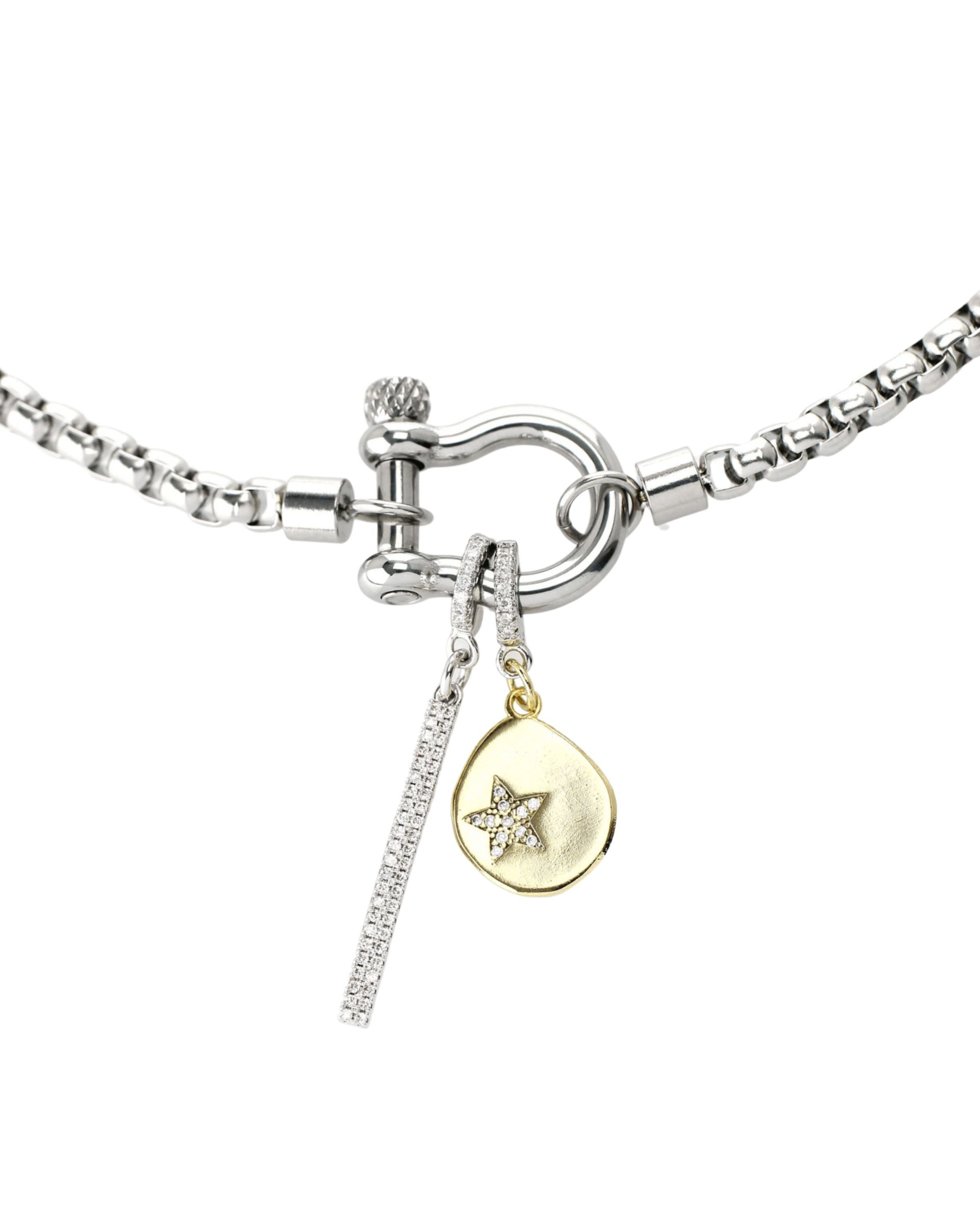 Model wearing the stylish Herradura Clip On Bar Necklace features a silver-toned chain with a unique gold-toned horseshoe clasp. It also includes a dangling bar charm and a celestial charm with sparkling details.