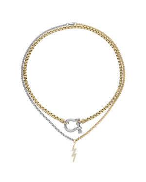 The Herradura Thunder Layered Necklace, a two-piece silver and gold necklace set featuring a box chain and a Cuban chain with a gold horseshoe clasp and a lightning bolt charm accented with diamond-like stones.