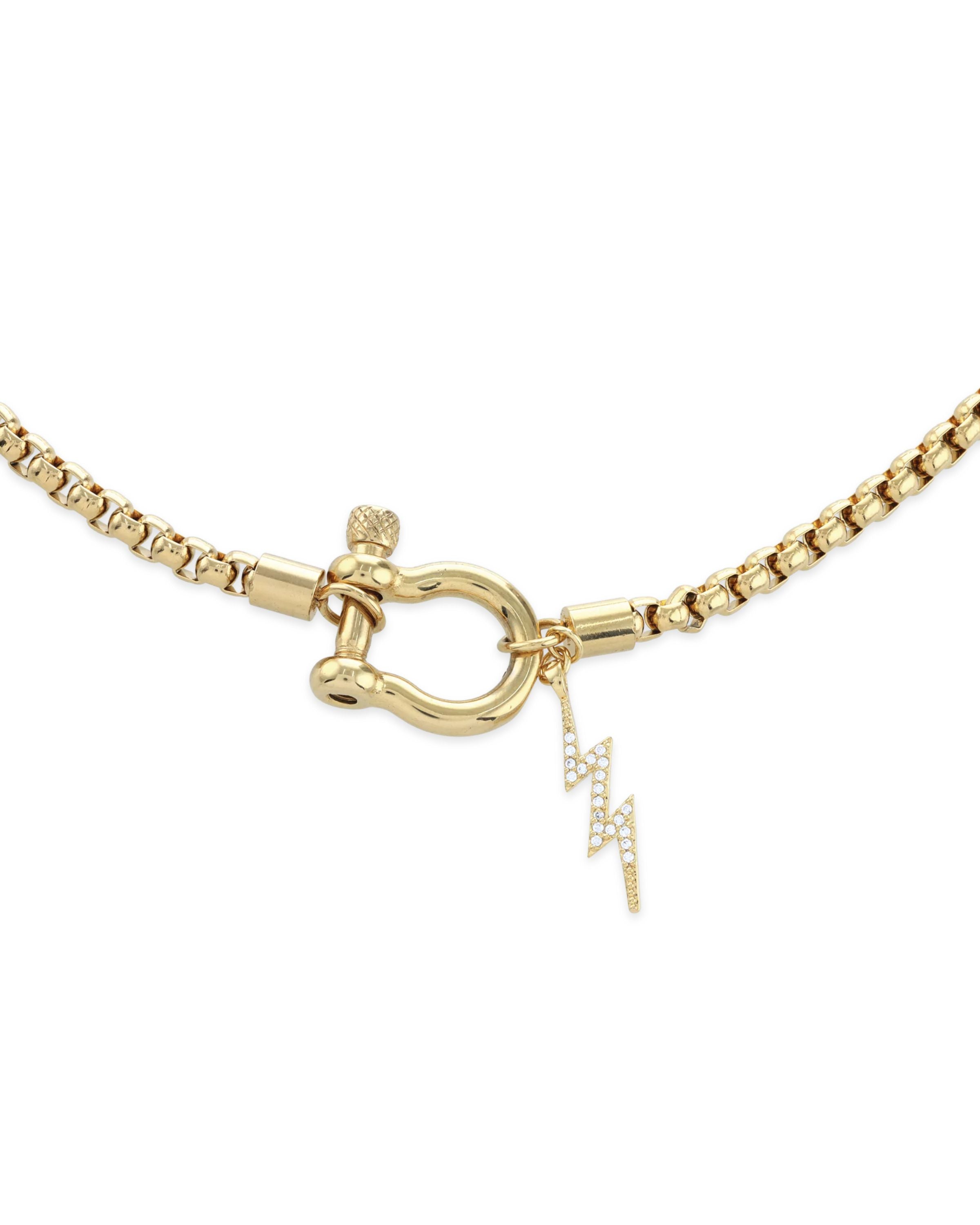 The Herradura Thunder Necklace - Gold, a single gold chain necklace featuring a bold clasp with a lightning bolt charm. This stylish and modern piece adds a touch of sparkle and edge, perfect for making a statement or layering with other gold accessories.