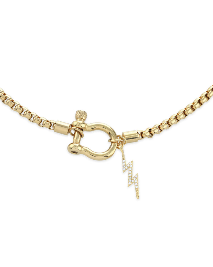 The Herradura Thunder Necklace - Gold, a single gold chain necklace featuring a bold clasp with a lightning bolt charm. This stylish and modern piece adds a touch of sparkle and edge, perfect for making a statement or layering with other gold accessories.