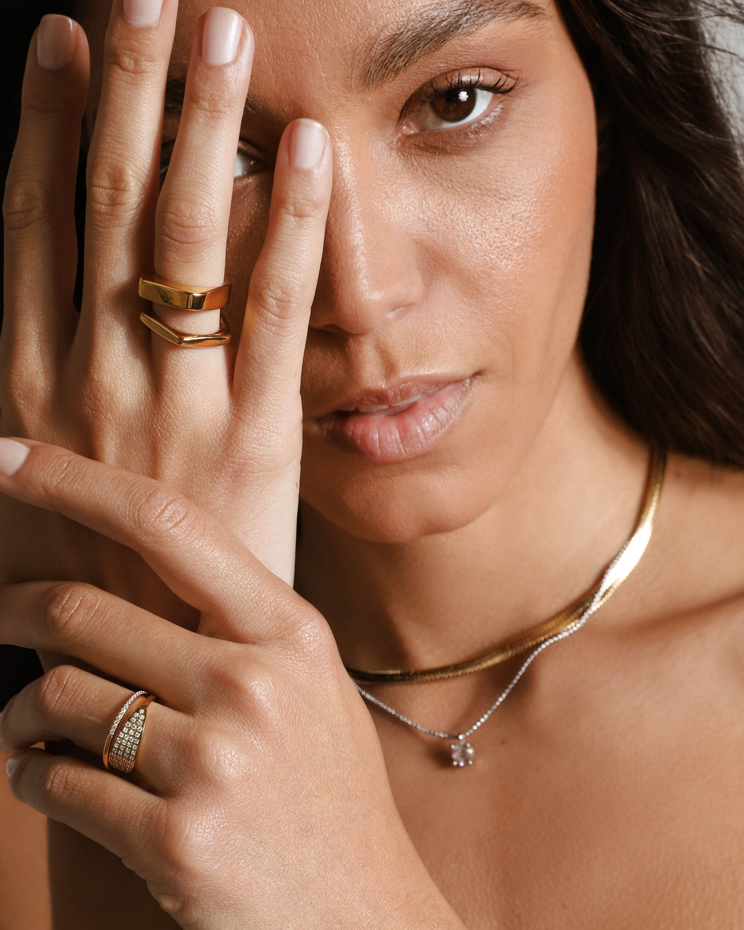 Model wearing The RECTANGLE RING which is an 18k Gold plated rectangular shaped ring together with the Rhombus ring. She is also wearing the snake necklace and a thin necklace with a cubic zirconia charm. 