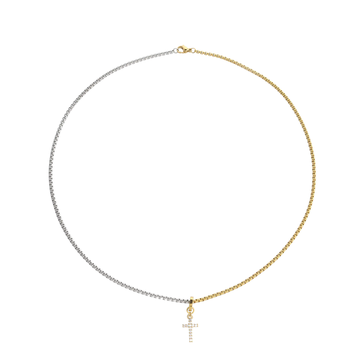 The CHARMED OPPOSITES NECKLACE, a two-tone necklace with half gold and half silver chain, featuring a small cross charm hanging from the center. |||  Cross Charm/MIX
