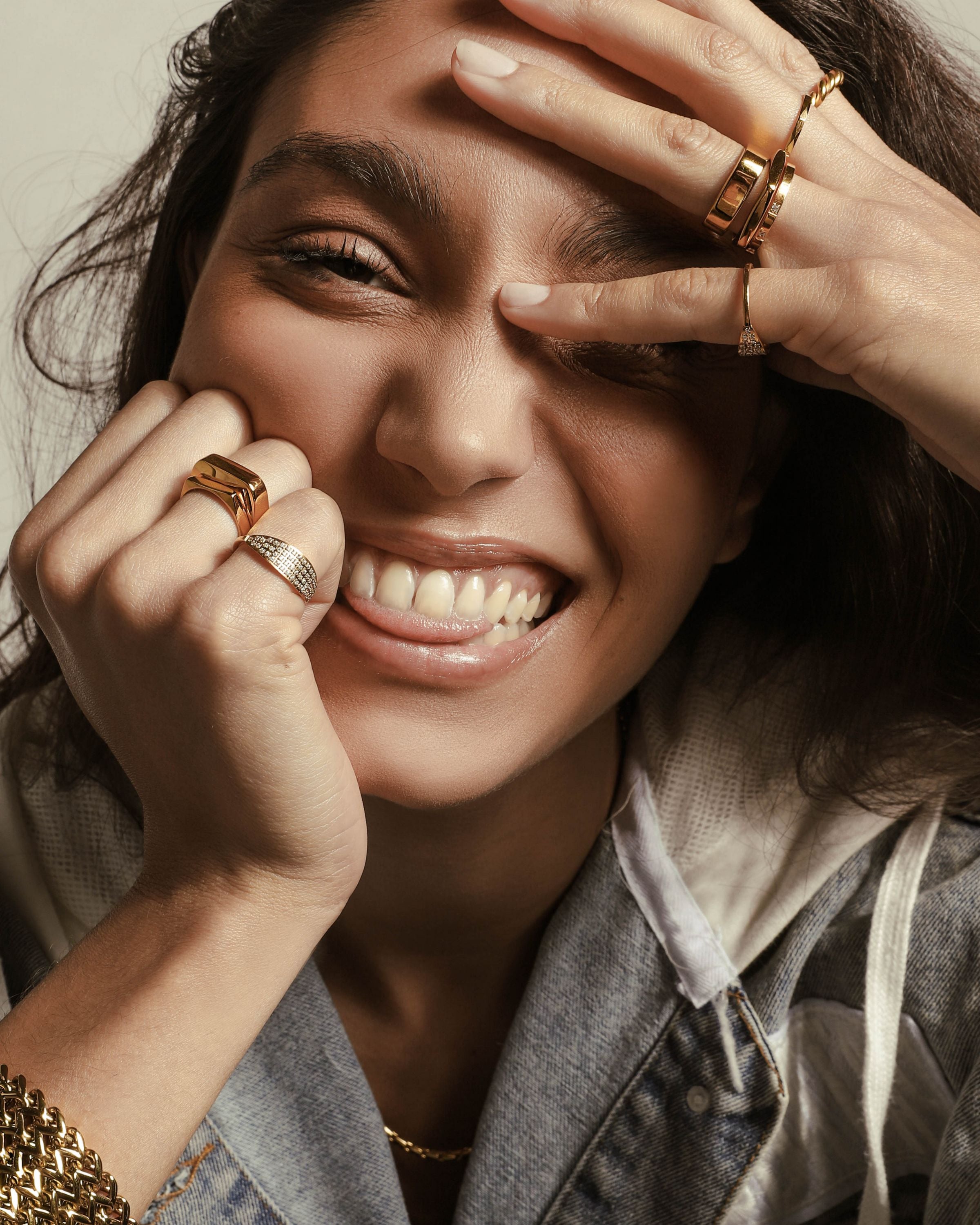 Model wearing The Thin RING which is an 18k Gold plated dainty thin ring stacked with the rectangle ring. She is also wearing other artizan rings and the braided chain cuff.