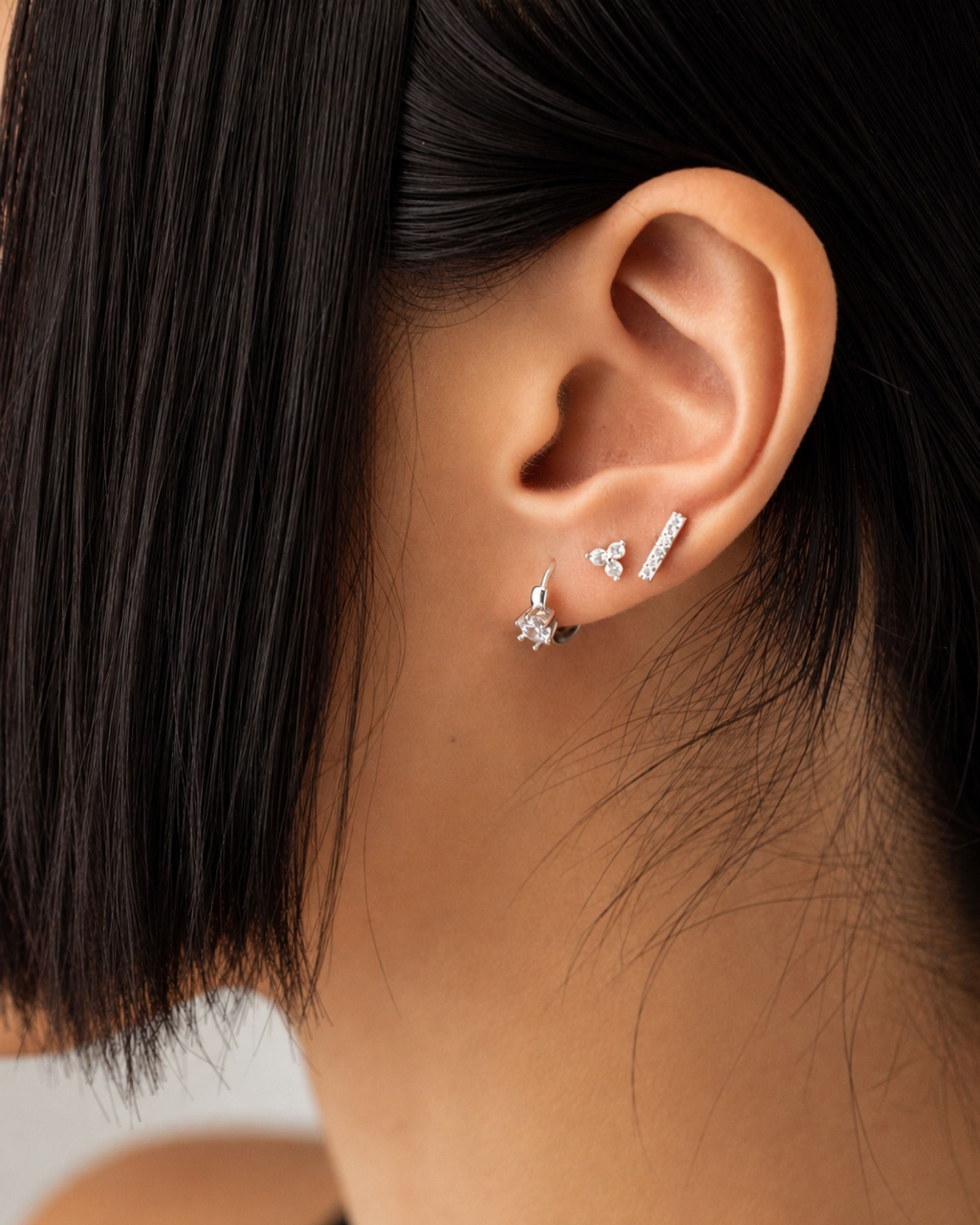 ear curation stack featuring three minimalist silver piercings set with clear cubic zirconia (CZ) stones.
