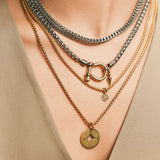 The Herradura Layered Necklace Set, a four-piece necklace set with a mix of gold and silver chains.

 It includes a silver chain with a signature horseshoe clasp, a chunky silver chain, and two delicate gold chains, one with a compass pendant and one with a spike pendant. |||Gold 
