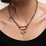 The Anne Charm Necklace, which is a delicate silver chain necklace featuring a multiple charm pendant, worn by a woman in a black top.