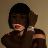 Model wearing the Supernova Tennis Stack, a set of 7 silver bracelets featuring various styles of tennis bracelets with sparkling cubic zirconia stones.