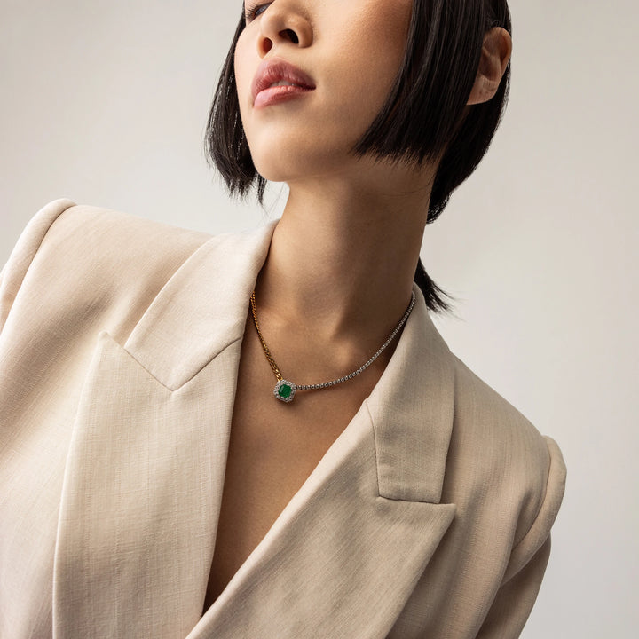 Model wearing the Mixed Emerald Chain, a gold and silver chain featuring a single emerald stone accented with a diamond-like halo.