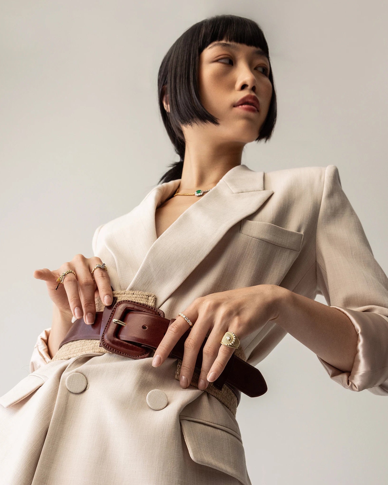 Model wearing the Abuela ring which is a gold textured statement ring with diamond accents in a unique wave design.