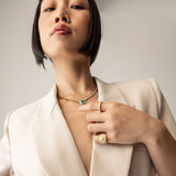 Model wearing the Abuela ring on her left pinky finger. it's a gold textured statement ring with diamond accents in a unique wave design.