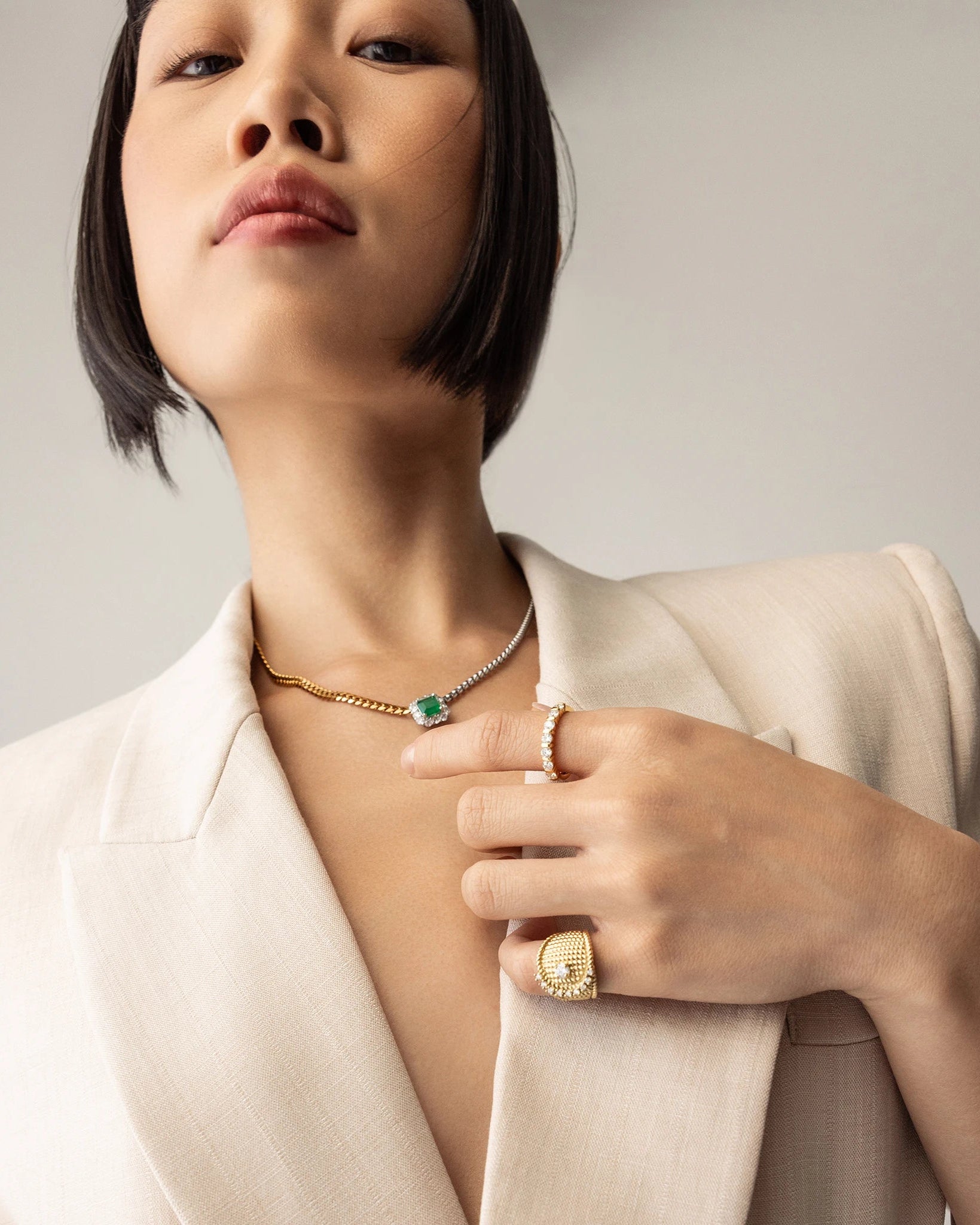 Model wearing the Abuela ring on her left pinky finger. it's a gold textured statement ring with diamond accents in a unique wave design.