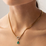 Model wearing a gold necklace with can opener clasp with the Emerald Teardrop Clip On Charm, a gold charm featuring a single teardrop-shaped emerald. ||| SILVER