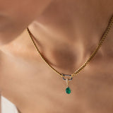 Model wearing a gold necklace with can opener clasp with the Emerald Teardrop Clip On Charm, a gold charm featuring a single teardrop-shaped emerald. ||| SILVER