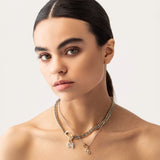 Model wearing the JUST CLICK CHARM PARTY NECKLACE SET showcasing mixed metal chains in gold and silver, adorned with delicate charms, including a lock, teardrop pendant, and crystal accents, elegantly styled on a model's neck.