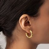Model wearing the Ringed-Up Bagel Hoops, a stunning pair of gold hoop earrings featuring a distinctive segmented design inspired by the shape of a bagel. 