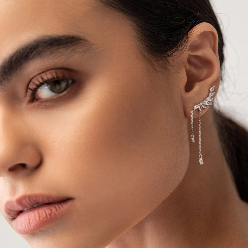 "The Butterfly Drop Earrings, which are silver earrings, feature a delicate wing-inspired design with shimmering stones and dainty drop chains, creating an elegant and modern look."