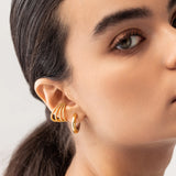 Model wearing the Full Eternity Ear Cuff, a bold gold-tone cuff adorned with sparkling stones, offering a statement look without piercings.|||Gold