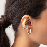 Model wearing the Slim Mix Huggies, a chic pair of two-tone hoop earrings features a combination of gold and silver tones and also a 4 hoop design diamond filled ear cuff.