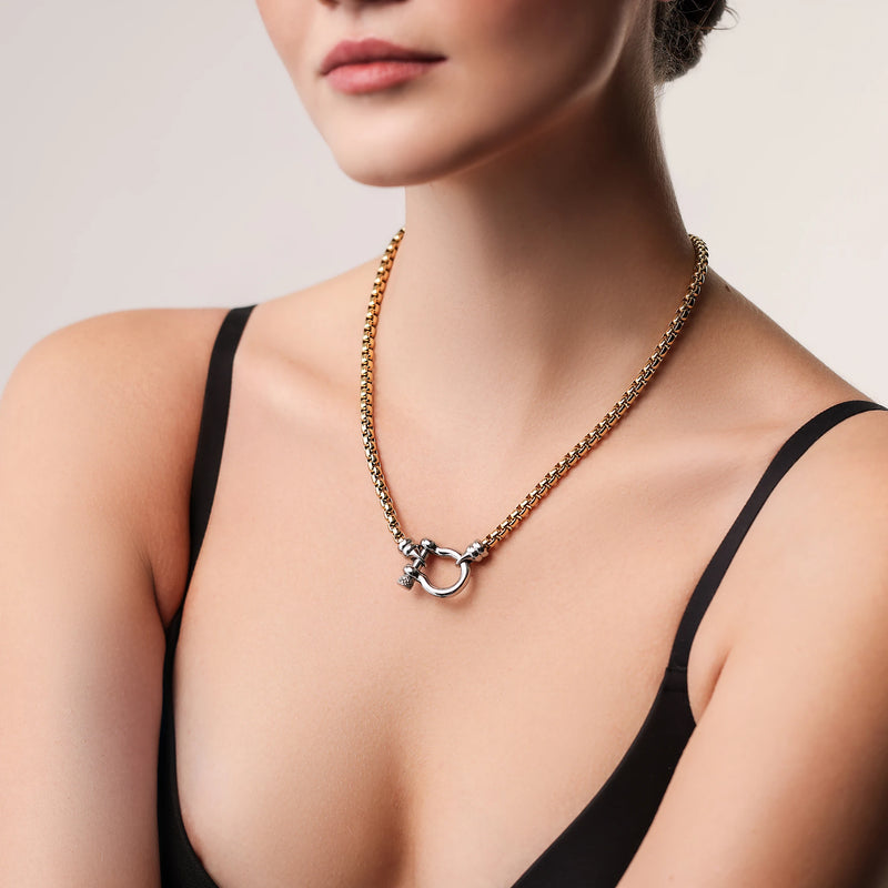 Model wearing the Herradura Signature Mix, a gold necklace featuring a box chain with a silver horseshoe clasp.