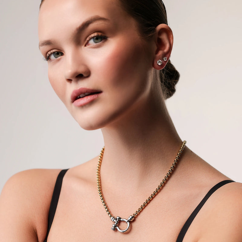 Model wearing the Herradura Signature Mix, a gold necklace featuring a box chain with a silver horseshoe clasp.