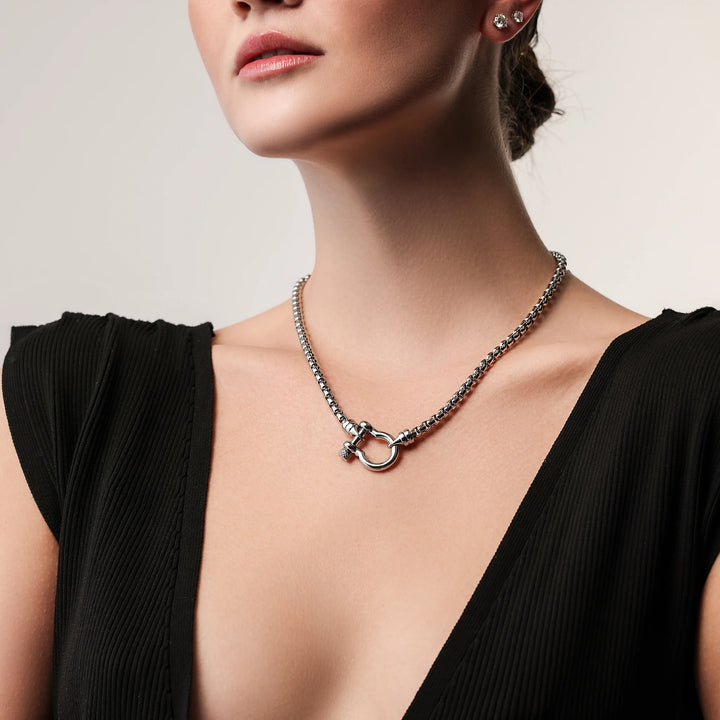 Model wearing the Herradura Signature in silver, a silver necklace featuring a box chain with a silver horseshoe clasp. ||| SILVER