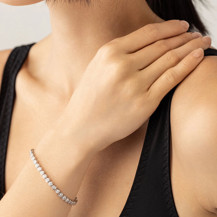 Model wearing the BUBBLE TENNIS BRACELET which is classic Tennis Bracelet featuring a row of 3mm Moissanite round diamonds set in a silver band