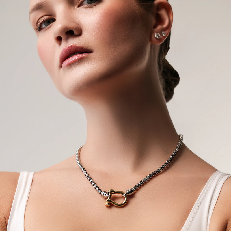 Model wearing the Herradura Signature Mix, a silver necklace featuring a box chain with a gold horseshoe clasp.