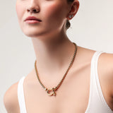 Model wearing the Herradura Signature, a gold necklace featuring a box chain with a gold horseshoe clasp. ||| GOLD