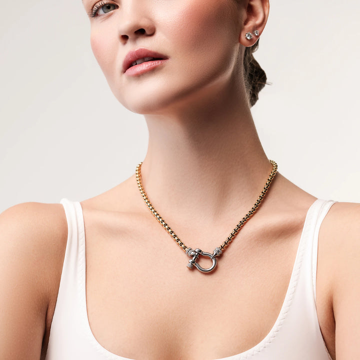 Model wearing the Herradura Signature Pave Mix, a gold necklace featuring a box chain with a silver horseshoe clasp accented with pave-set diamond-like stones.  |||Silver