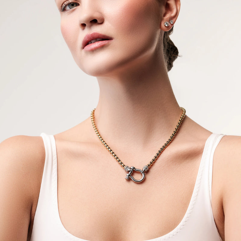 Model wearing the Herradura Signature Pave Mix, a gold necklace featuring a box chain with a silver horseshoe clasp accented with pave-set diamond-like stones.