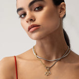 Model wearing the Classic Tennis Necklace featuring a row of round diamonds set in a silver chain. Also the  mix can opener necklace with the Go North and DAVID’S STAR CLIP ON CHARMS.