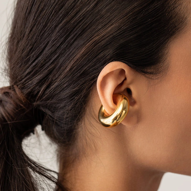 Model wearing the Chunky Bagel Ear Cuff, a gold ear cuff with a thick, rounded design.