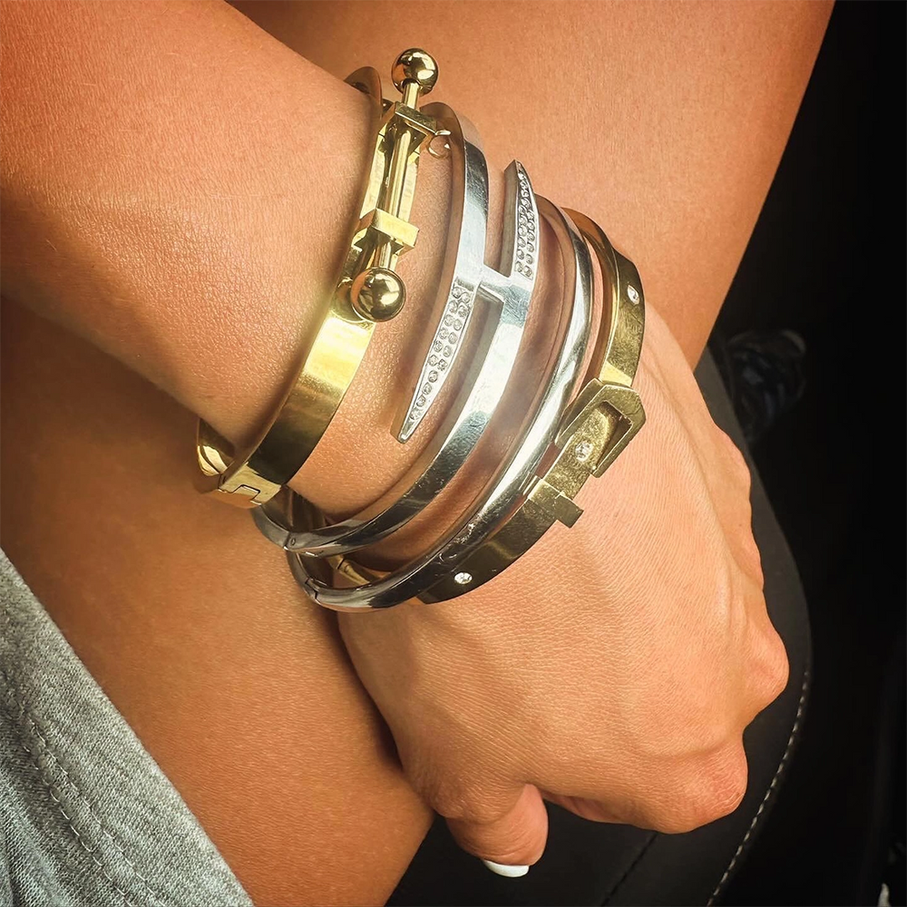 A woman's wrist wearing a khanti stack of gold and silver bracelets from artizan joyeria