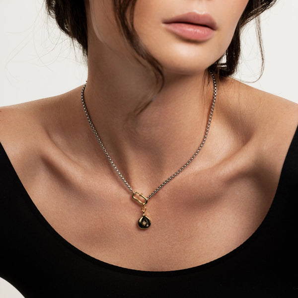 The Box Charm Necklace, which is a single gold and silver necklace featuring a unique box-shaped charm. The charm has a sleek, modern design, adding a bold and elegant touch to the minimalist chain.