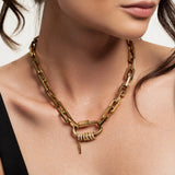Model wearing the Carabiner Square Spiga Necklace, a chunky gold chain with a carabiner clasp and pavé-studded ring and charm accents.