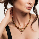 Model wearing the Carabiner Square Spiga Necklace, a chunky gold chain with a carabiner clasp and pavé-studded ring and charm accents.
