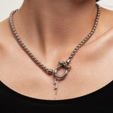 The Herradura Thunder Silver, which is a bold silver chain necklace featuring a toggle clasp with a lightning bolt pendant, worn by a woman in a black off-shoulder top.