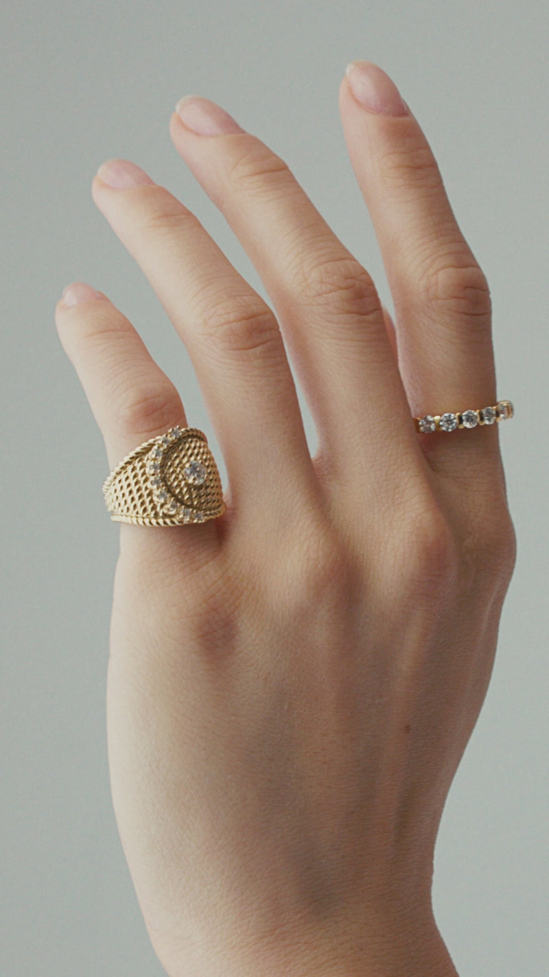 The Abuela Ring worn on the pinky finger which is a Gold textured statement ring with diamond accents in a unique wave design.