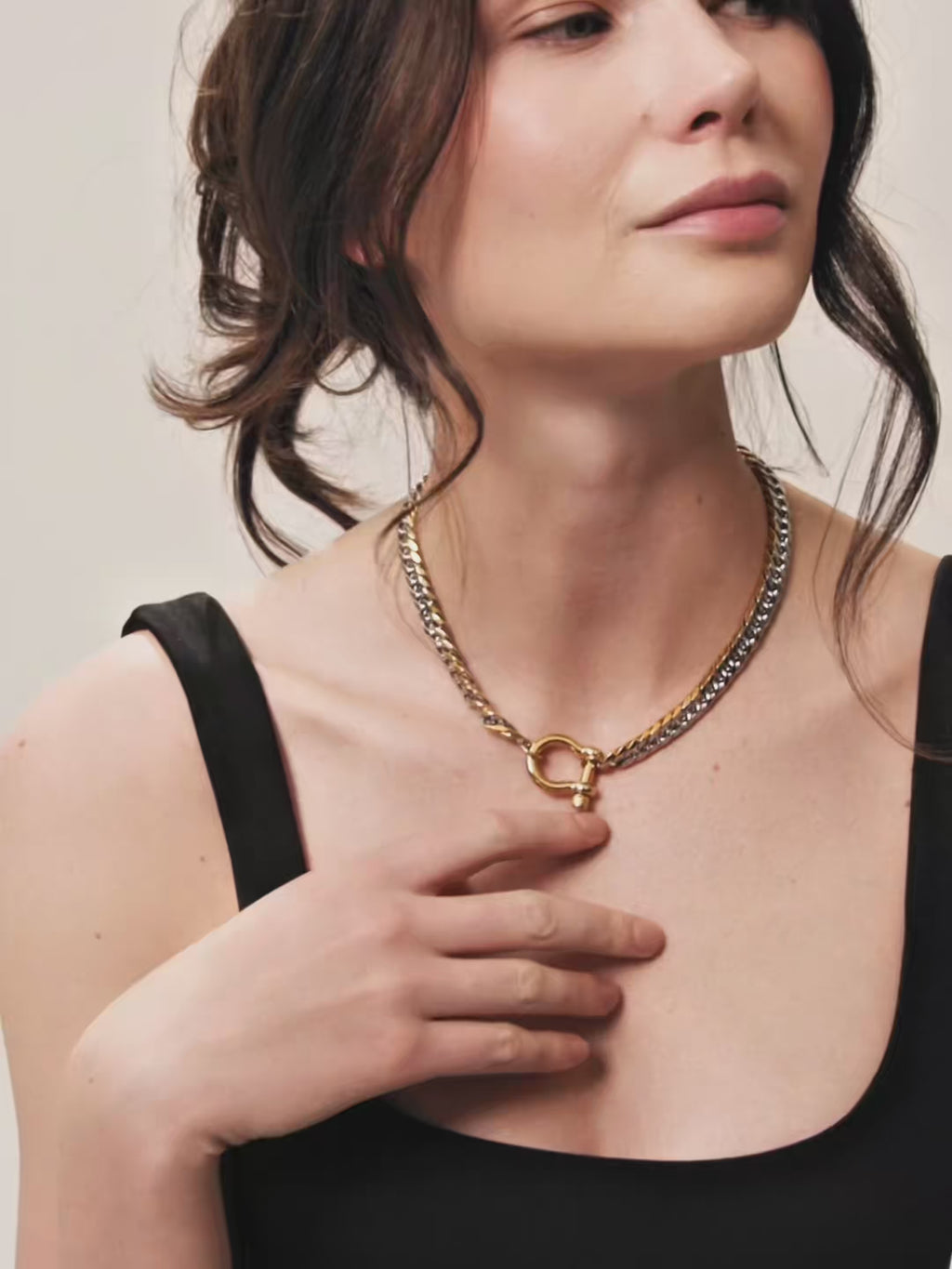 The Herradura Tropicana Mix, which is a mixed metal necklace featuring a gold and silver chain with a toggle clasp, worn by a woman in a black top. ||| 