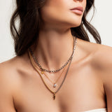 The Shini Spike Trio Necklace Set, a set of three layered necklaces in mixed gold and silver tones, featuring a combination of delicate chains, a crystal charm, and a bold spike pendant, worn by a model.