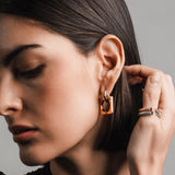 Gold and silver **Square Mix Hoops Earrings**, styled with three stacked gold and silver rings, including a diamond ring, for a modern and edgy look.