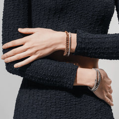 Two-piece layered bracelet stack in gold and silver on one wrist, and a two-piece silver bracelet stack on the other, featuring chunky chain and diamond-accented designs. ||| GOLD